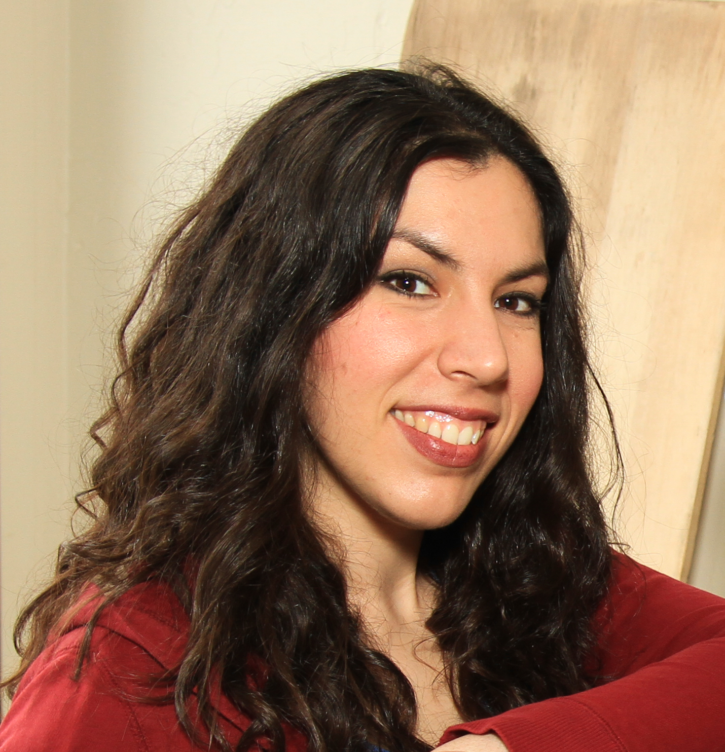 Portrait of smiling woman with light skin and long, slightly disheveled brown hair