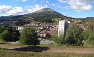 Landscape of homes and buildings along the foot of a mountain.