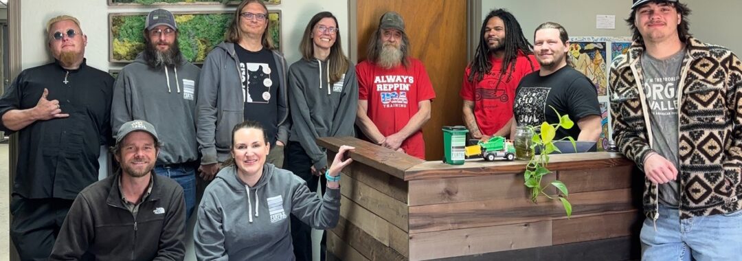 group photo of ten people standing in an office and smiling