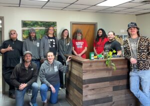 group photo of ten people standing in an office and smiling