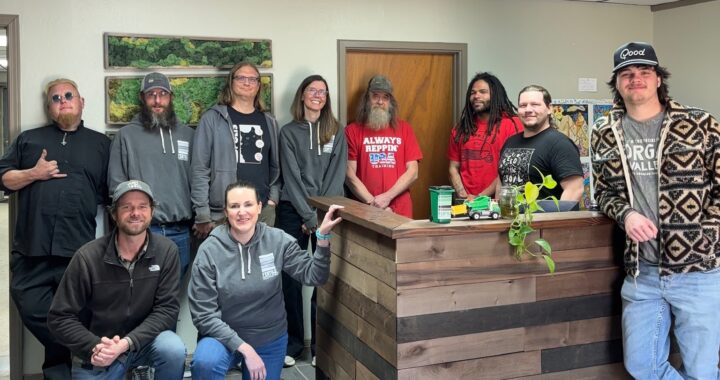 group photo of ten people standing in an office and smiling