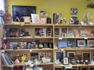 A wall with shelves of various artwork like sculptures and more