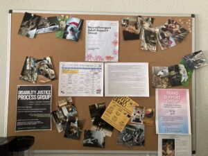 a cork board with flyers that read trans right support group, neurodivergent adult support group and more